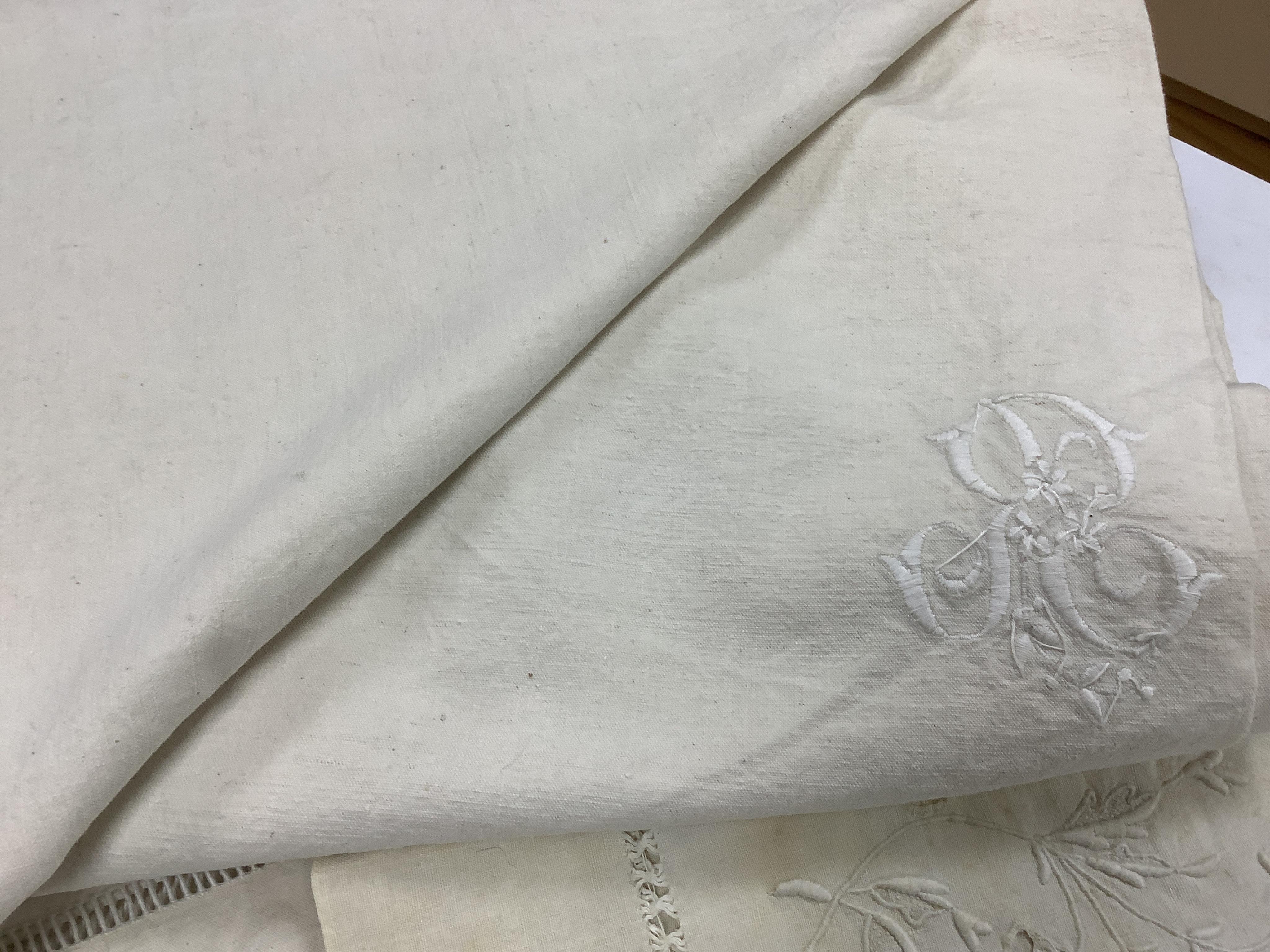 Four 19th century French provincial linen top sheets. Two with deep heavily floral embroidered turn backs, another with tear drops embroidered on the turn back, the other a narrower sheet with a single embroidered monogr